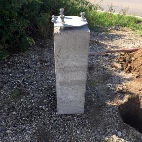 Glasfiberstang med vippebeslag istøbt betonklods - Glasfiberstang med vippebeslag og betonfundament.